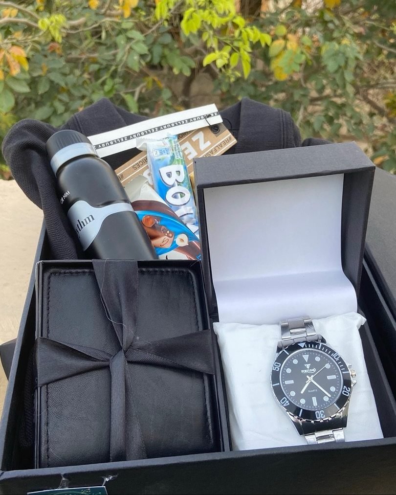 Curated gift box for men featuring a watch, wallet, thermos, and black hoodie.