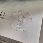 Embossed library seal on a white book page with a mythical creature design.