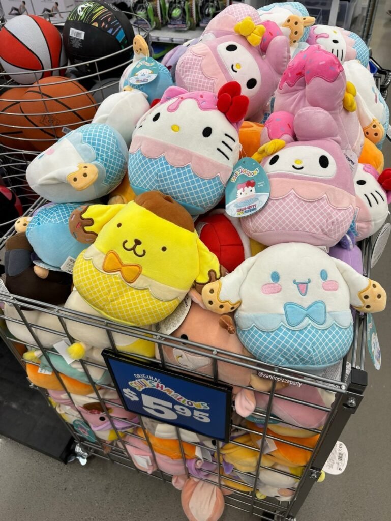Various Sanrio Squishmallows plush toys, including Hello Kitty, piled in a metal store bin.