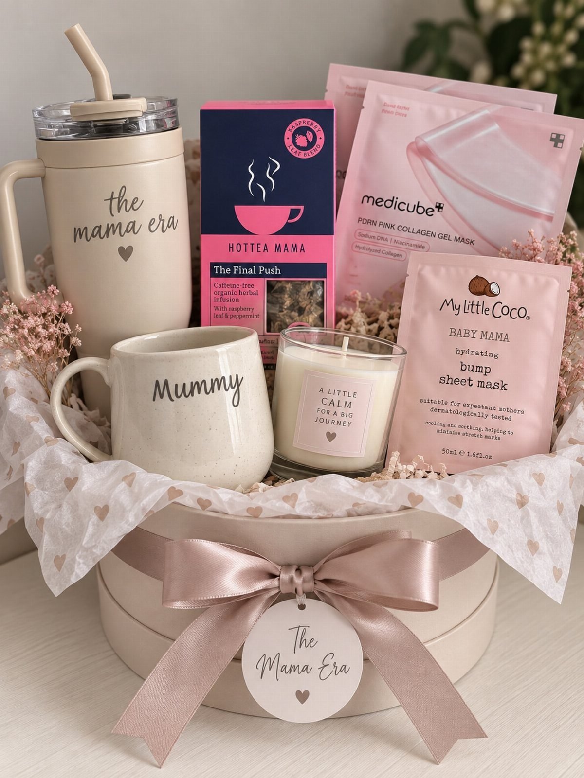 Gift basket for an expectant mother with mugs, candle, and skincare in a box.