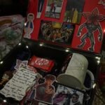 Stranger Things themed gift box with character cutouts, photos, a mug, and candy.