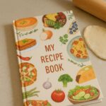 Recipe book with food illustrations on a kitchen counter with a rolling pin