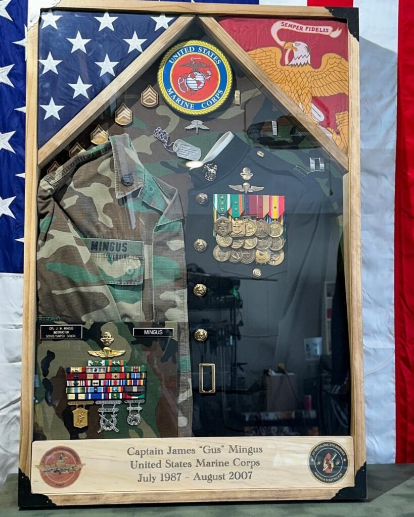 Military shadow box display with camouflage uniform, medals, and personalized nameplate for a veteran.